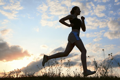 Silhouette woman run under blue sky with clouds and sun